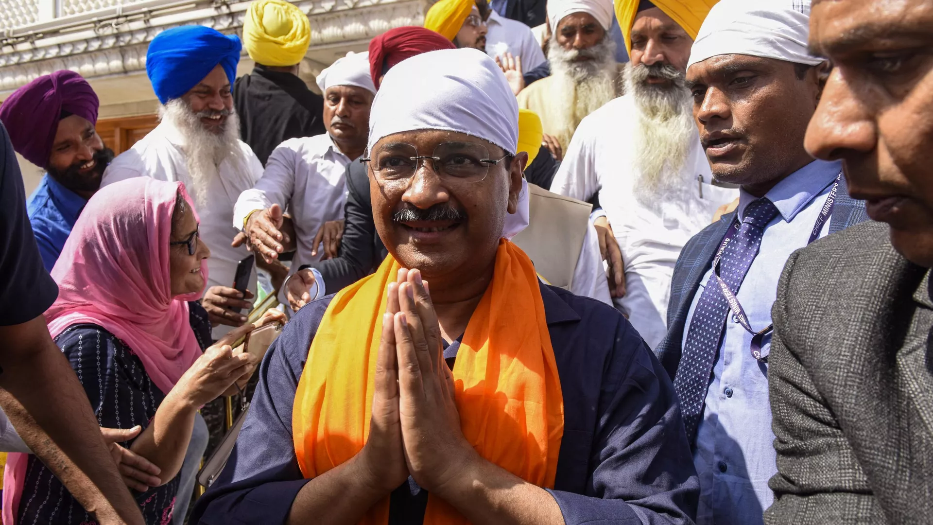 Aam Aadmi Party (AAP) leader and Delhi's chief minister Arvind Kejriwal (C, white headgear) pay respect at the Golden Temple in Amritsar on March 13, 2022.