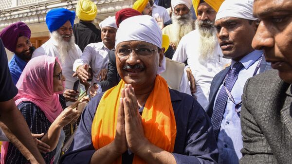 Aam Aadmi Party (AAP) leader and Delhi's chief minister Arvind Kejriwal (C, white headgear) pay respect at the Golden Temple in Amritsar on March 13, 2022. - Sputnik India