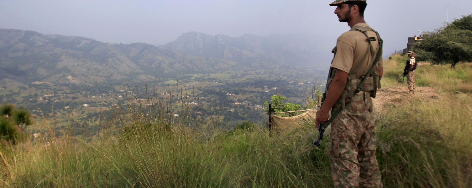 In this Oct. 1, 2016, file photo, Pakistan army soldiers monitor the area from the hilltop Bagsar post on the line of control, that divides Kashmir between Pakistan and India, near Bhimber, some 166 kilometers (103 miles) from Islamabad, Pakistan. - Sputnik India, 1920, 13.12.2022