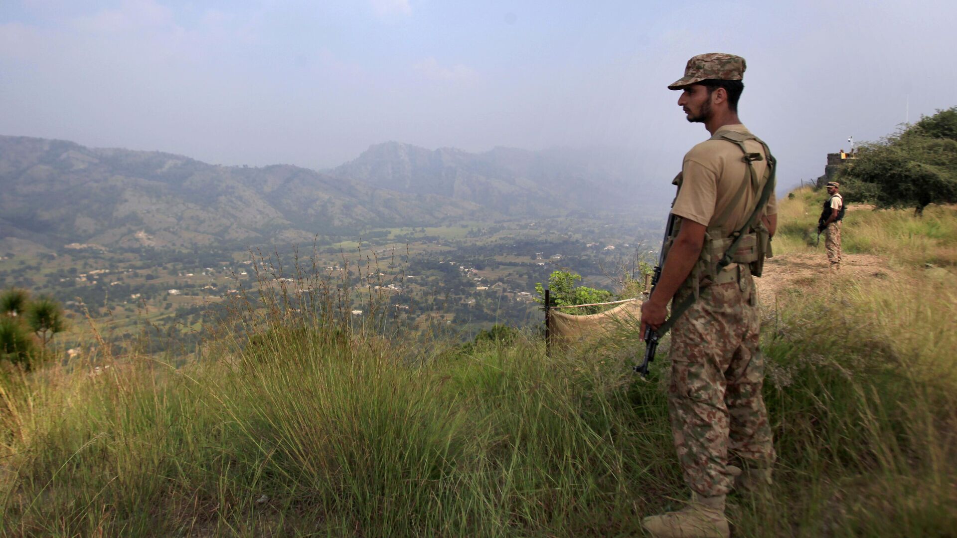 In this Oct. 1, 2016, file photo, Pakistan army soldiers monitor the area from the hilltop Bagsar post on the line of control, that divides Kashmir between Pakistan and India, near Bhimber, some 166 kilometers (103 miles) from Islamabad, Pakistan. - Sputnik India, 1920, 13.12.2022