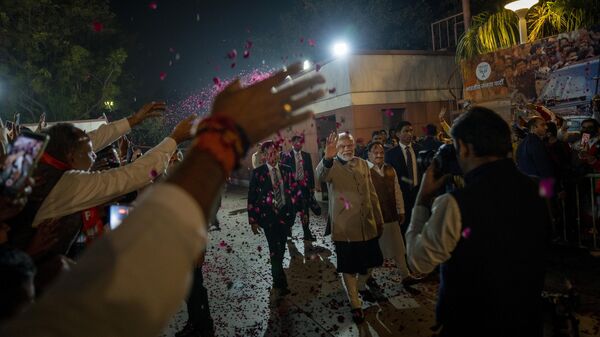 Supporters shower flower petals as Indian Prime Minister Narendra Modi arrives at the Bharatiya Janata party (BJP) headquarters in New Delhi, India, Thursday, Dec. 8, 2022. - Sputnik भारत
