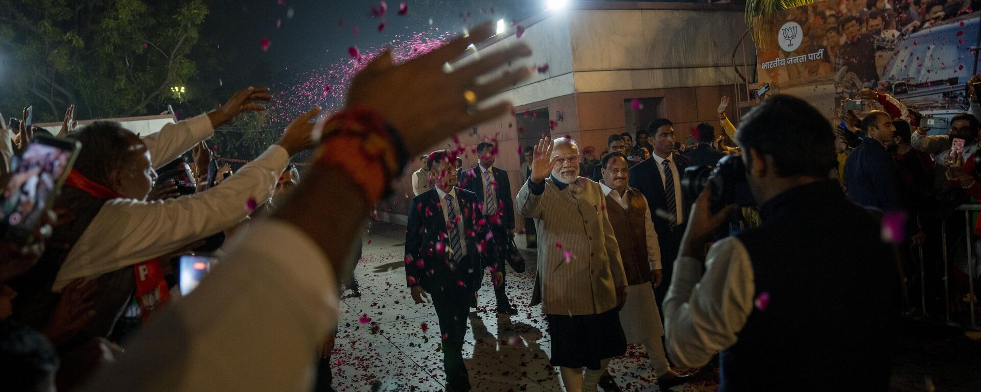Supporters shower flower petals as Indian Prime Minister Narendra Modi arrives at the Bharatiya Janata party (BJP) headquarters in New Delhi, India, Thursday, Dec. 8, 2022. - Sputnik India, 1920, 13.12.2022