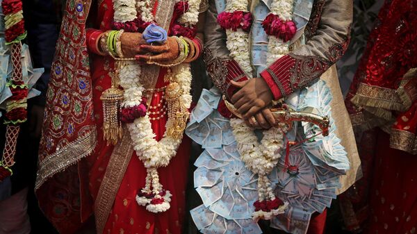 A newly wed Indian couple poses for photographs during a mass marriage ceremony for eight couples in New Delhi, India, Friday, March 8, 2019. - Sputnik भारत