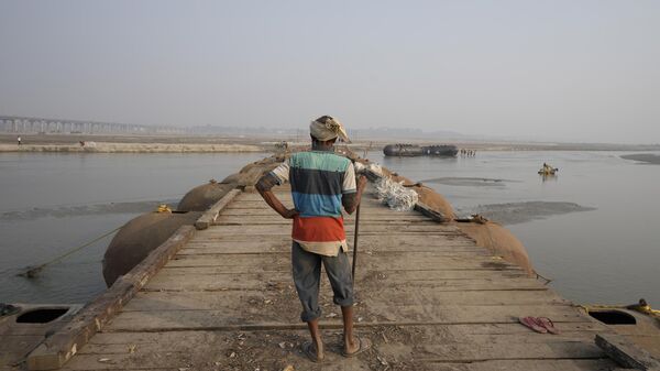A laborer works on a pontoon bridge on the river Ganges for the upcoming Magh Mela festival, in Prayagraj, in the northern Indian state of Uttar Pradesh, , India. Friday, Dec. 9, 2022. - Sputnik India