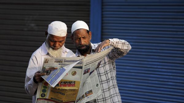 Indian Muslims read about the verdict in a decades-old land title dispute between Muslims and Hindus in a newspaper in Ayodhya, India, Sunday, Nov. 10, 2019. - Sputnik भारत