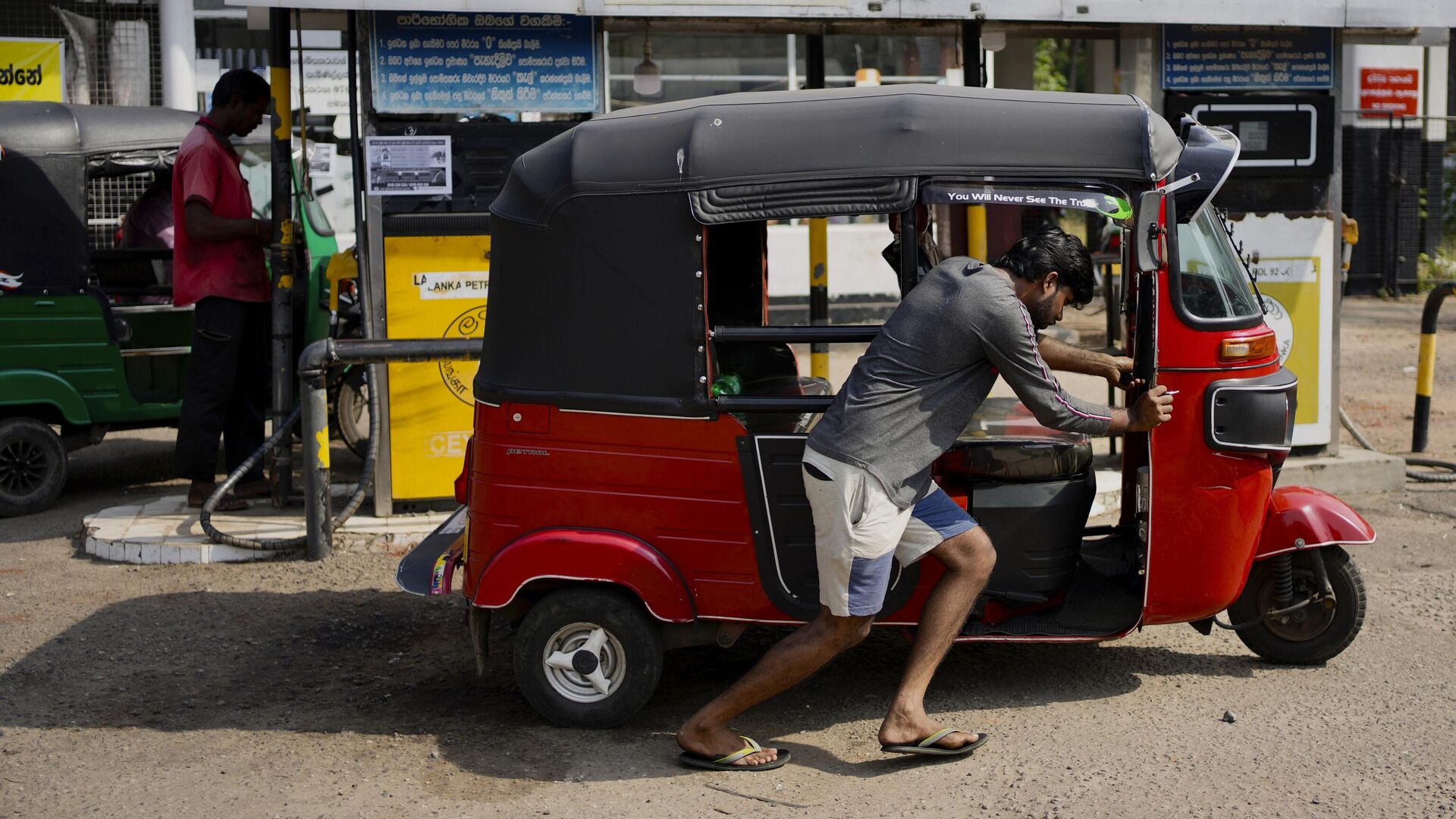 A man pushes his autorickshaw to a fuel station in Colombo, Sri Lanka, Wednesday, July 27, 2022. - Sputnik India, 1920, 16.02.2023