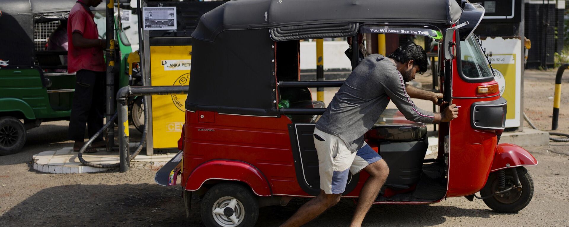 A man pushes his autorickshaw to a fuel station in Colombo, Sri Lanka, Wednesday, July 27, 2022. - Sputnik India, 1920, 13.01.2023