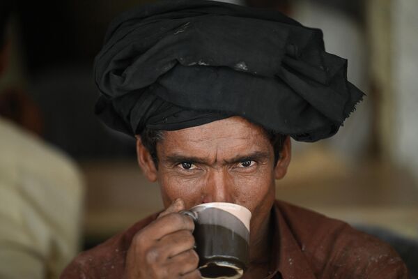 Men drink a cup of tea at a roadside restaurant in Islamabad on June 15, 2022. - Sputnik India