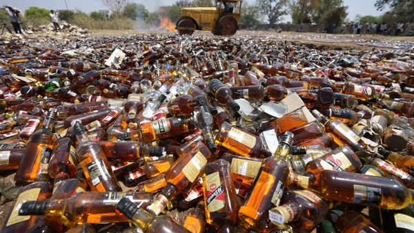 A road roller is used to destroy seized liquor bottles as police officials oversee in Ahmedabad, Gujarat state, India, Wednesday, March 30, 2022. - Sputnik India