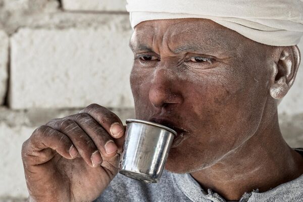 A labourer sips on a cup of tea at the White Mountain limestone extraction quarry site near Egypt's southern city of Minya, some 265 kilometres south of the capital, on December 7, 2019. - Sputnik India