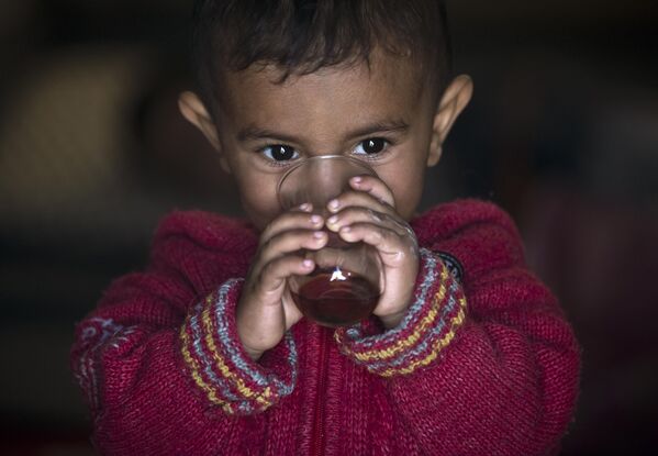 A Syrian Kurdish refugee child from the Kobani area, drinks tea at a camp in Suruc, on the Turkey-Syria border Wednesday, Nov. 12, 2014. - Sputnik India