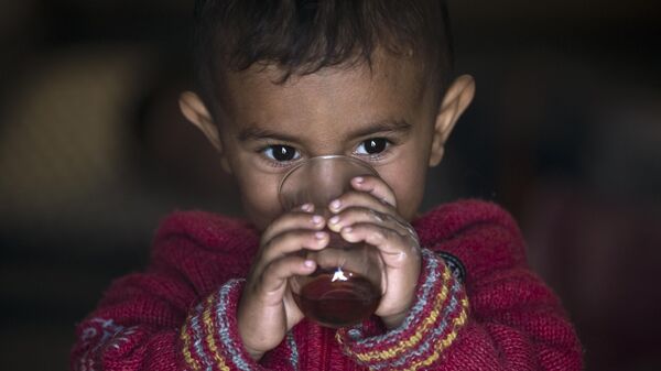 A Syrian Kurdish refugee child from the Kobani area, drinks tea at a camp in Suruc, on the Turkey-Syria border Wednesday, Nov. 12, 2014. - Sputnik India