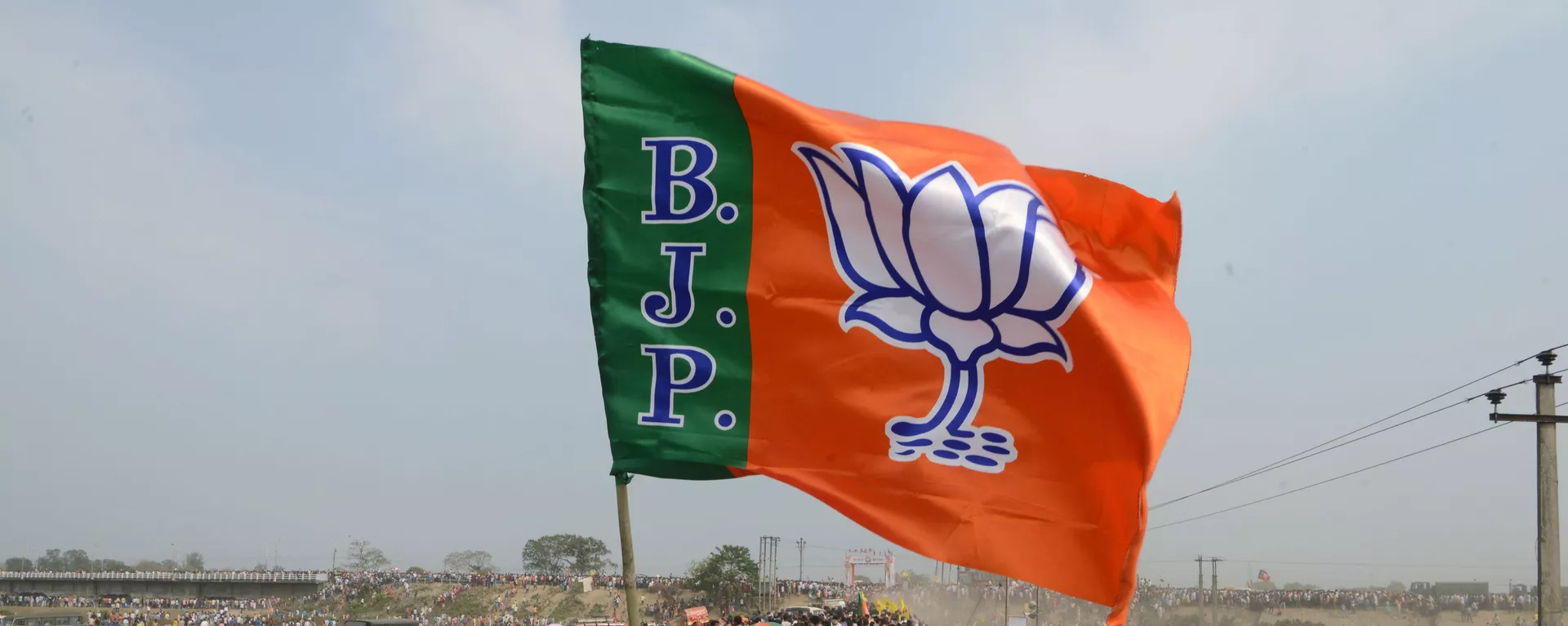 Indian supporters of the Bharatiya Janata Party (BJP) carry a party flag on their way to attend a campaign rally while wearing masks of Indian Prime Minister Narendra Modi ahead of the national elections in Siliguri on April 3, 2019 - Sputnik India, 1920, 27.05.2023