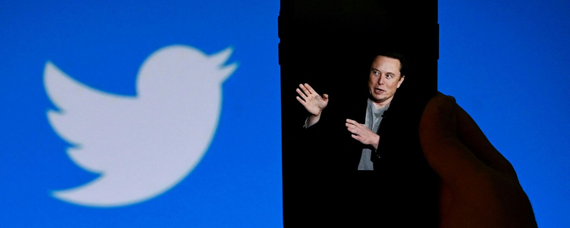 In this photo taken on October 4, 2022, a phone screen displays a photo of Elon Musk with the Twitter logo shown in the background, in Washington, DC - Sputnik India, 1920, 03.01.2023
