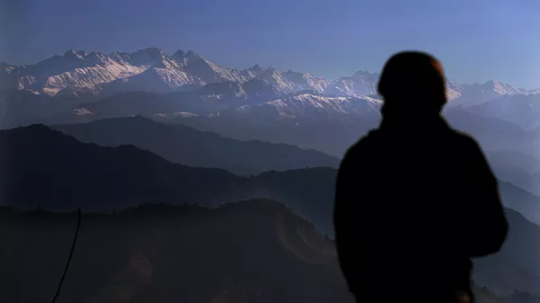 An Indian army soldier looks towards the snow-covered Pir Panjal range of mountains from one of their forward post at the Line of Control (LOC) between India and Pakistan border, in Poonch, about 248 kilometers (155 miles) from Jammu, India, Wednesday, Dec. 16, 2020 - Sputnik भारत