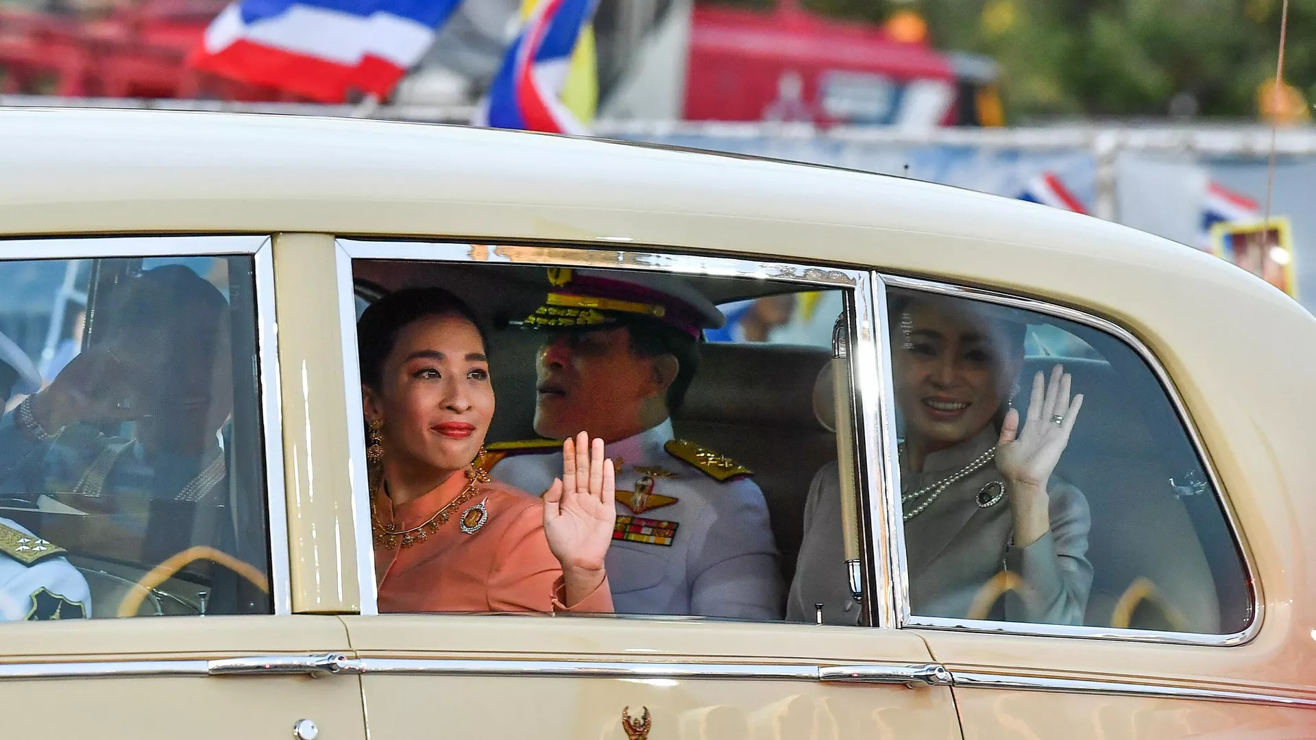 In this file photo taken on November 1, 2020 Thai Princess Bajrakitiyabha Mahidol (centre L) waves from a car, sitting next to Thailand's King Maha Vajiralongkorn (C) and Queen Suthida (R), on arrival at the Grand Palace in Bangkok.