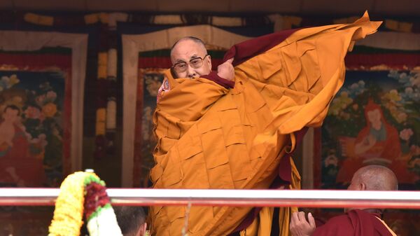 Exiled Tibetan spiritual leader the Dalai Lama adjusts his shawl as he came to deliver his religious teaching at Yiga Choezin ground at in Tawang District near India-china border in India's north-eastern state of Arunachal Pradesh state, on April 8, 2017 - Sputnik भारत
