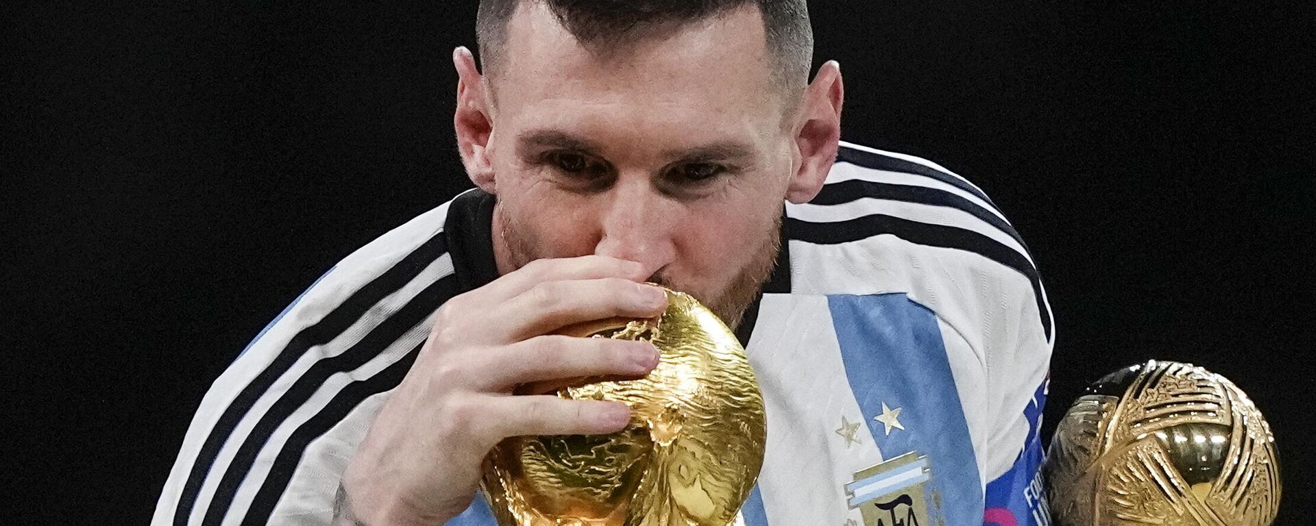 Argentina's Lionel Messi kisses the World Cup trophy with the golden ball trophy in his hand after the World Cup final soccer match between Argentina and France at the Lusail Stadium in Lusail, Qatar, Sunday, Dec. 18, 2022. - Sputnik India, 1920, 21.12.2022