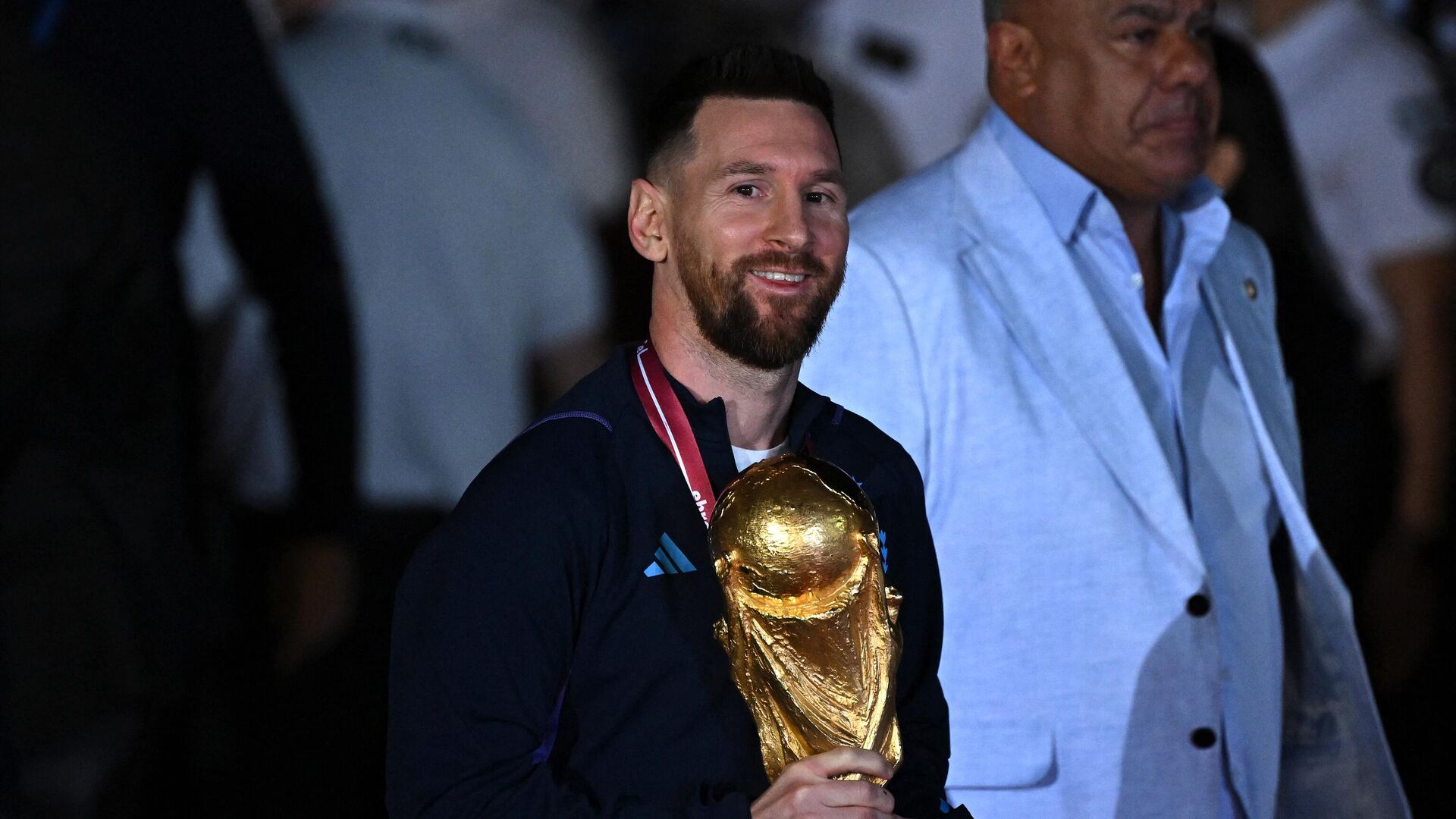 Argentina's captain and forward Lionel Messi (C) holds the FIFA World Cup Trophy upon arrival at Ezeiza International Airport after winning the Qatar 2022 World Cup tournament in Ezeiza, Buenos Aires province, Argentina on December 20, 2022. - Sputnik India, 1920, 22.12.2022