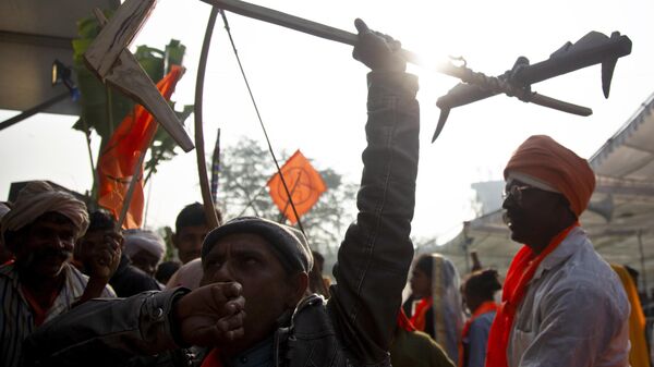 A farmer holds up a plough as he participates in a rally in New Delhi, India, Monday, Dec. 19, 2022. - Sputnik India