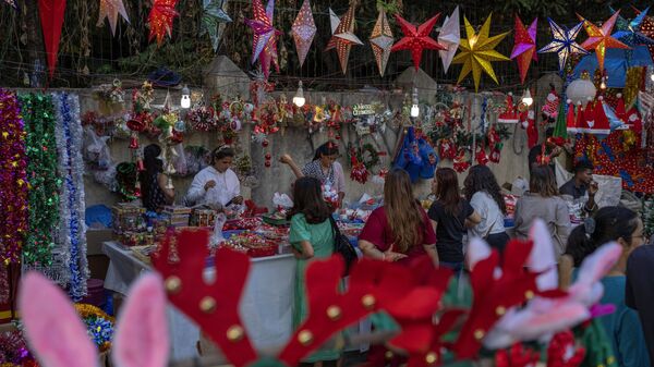 People shop for Christmas souvenirs from roadside vendors in Mumbai, India, Tuesday, Dec. 20, 2022. - Sputnik भारत