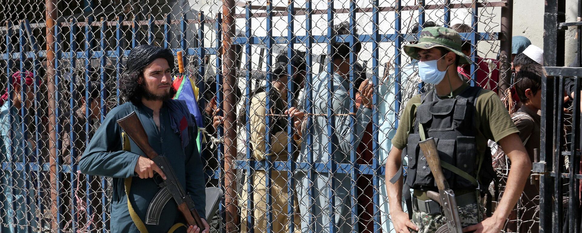 FILE - A Pakistani paramilitary soldier, right, and a Taliban fighter stand guard on their respective sides at a border crossing point between Pakistan and Afghanistan, in Torkham, in the Khyber district of Pakistan, Aug. 21, 2021 - Sputnik भारत, 1920, 07.06.2023