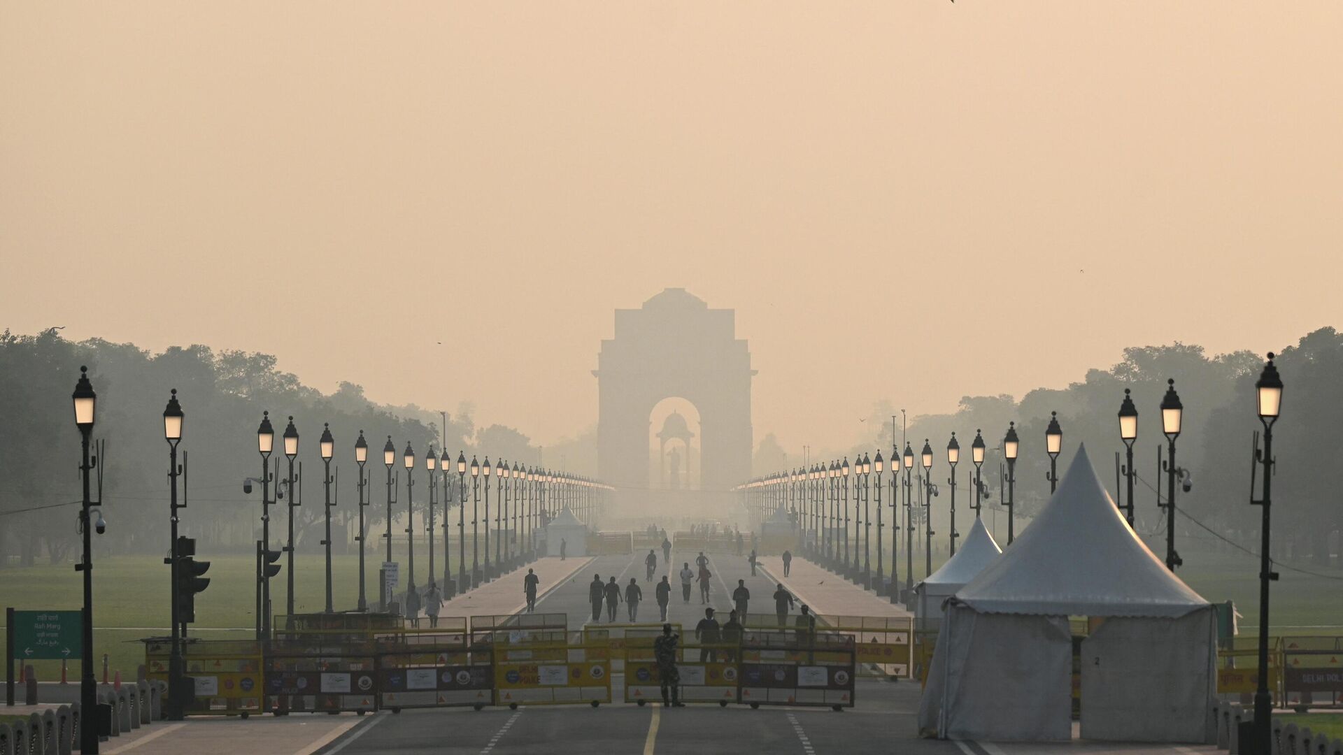 People walk along a road near India Gate amid smoggy conditions in New Delhi on October 25, 2022. - Sputnik India, 1920, 09.01.2023