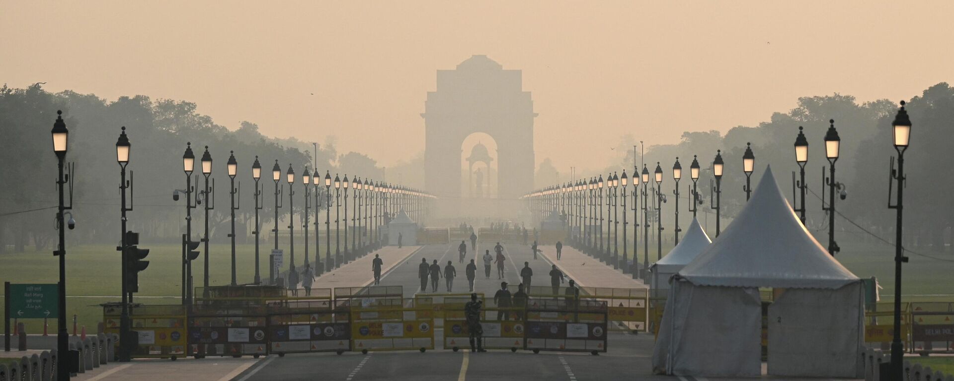 People walk along a road near India Gate amid smoggy conditions in New Delhi on October 25, 2022. - Sputnik India, 1920, 24.01.2023