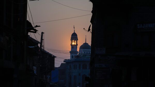 Sun sets behind the minarets of a Mosque in old town area of Srinagar, Thursday, Dec.15, 2022. - Sputnik India