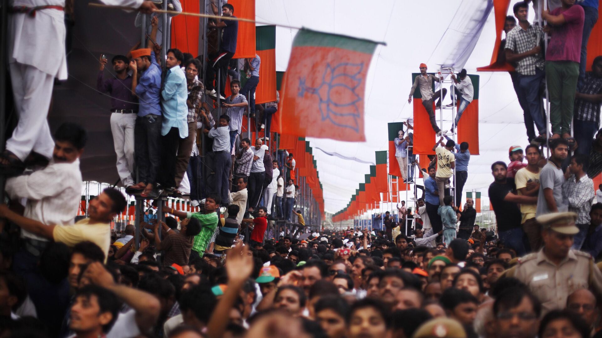 Supporters climb on poles for a better view as India’s opposition Bharatiya Janata Party (BJP) leader Narendra Modi addresses a public rally in New Delhi, India, Sunday, Sept. 29, 2013. - Sputnik India, 1920, 25.05.2023