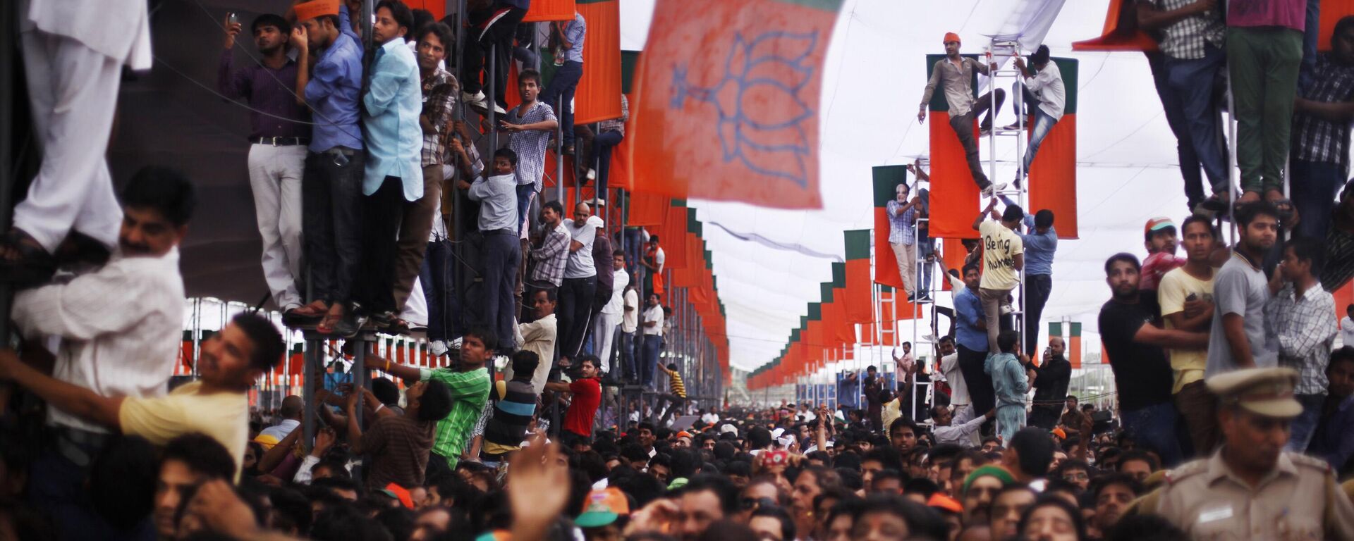 Supporters climb on poles for a better view as India’s opposition Bharatiya Janata Party (BJP) leader Narendra Modi addresses a public rally in New Delhi, India, Sunday, Sept. 29, 2013. - Sputnik India, 1920, 25.10.2023