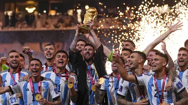 Argentina's Lionel Messi holds up the trophy after winning the World Cup final soccer match between Argentina and France at the Lusail Stadium in Lusail, Qatar, Sunday, Dec.18, 2022. - Sputnik India