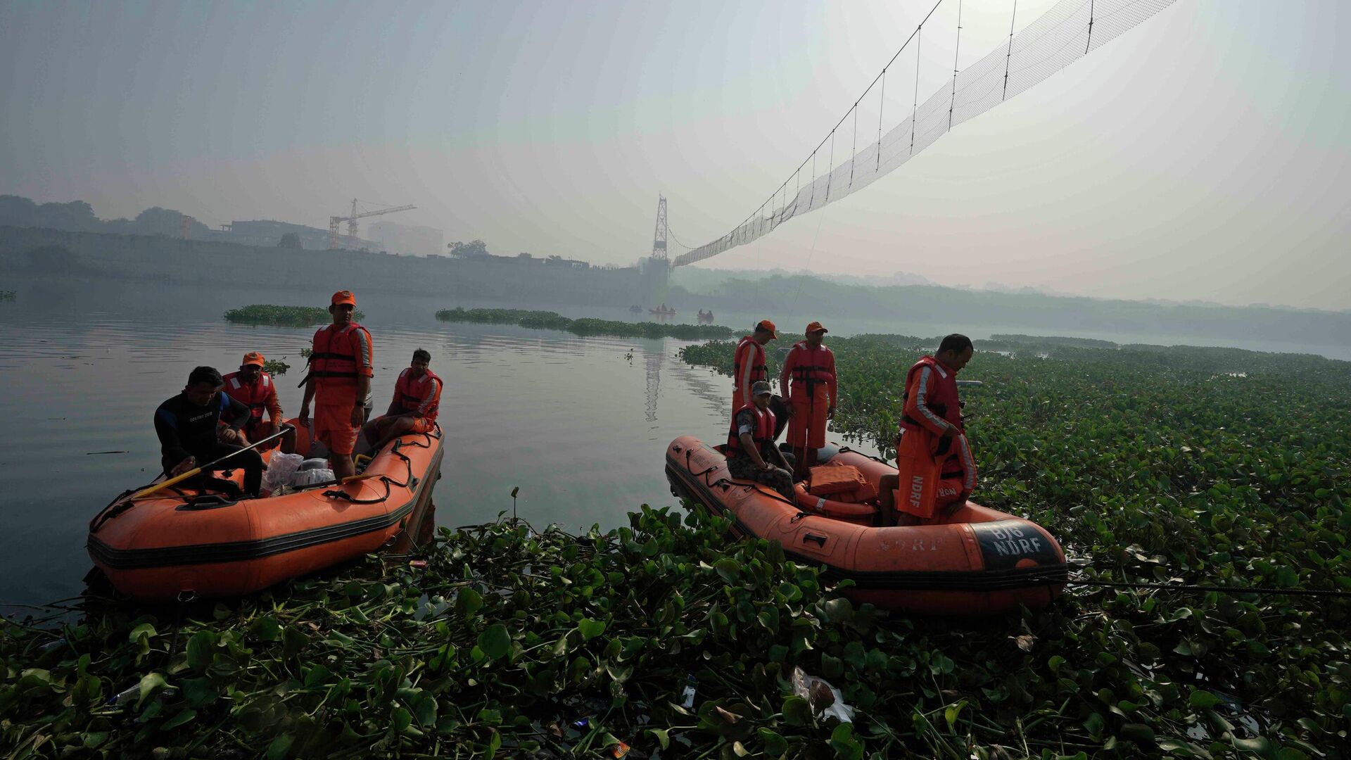 Rescuers on boats search in the Machchhu river next to a cable bridge that collapsed on Sunday in Morbi town of western state Gujarat, India, Wednesday, Nov. 2, 2022. - Sputnik India, 1920, 31.01.2023