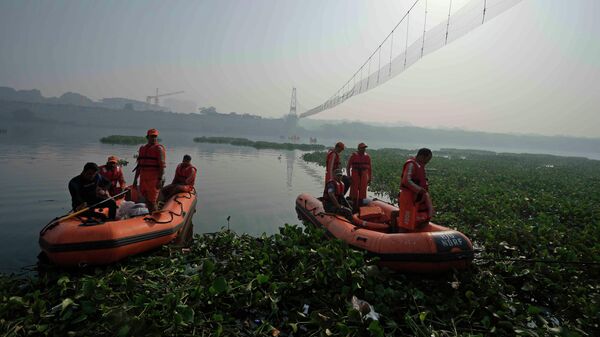 Rescuers on boats search in the Machchhu river next to a cable bridge that collapsed on Sunday in Morbi town of western state Gujarat, India, Wednesday, Nov. 2, 2022. - Sputnik India