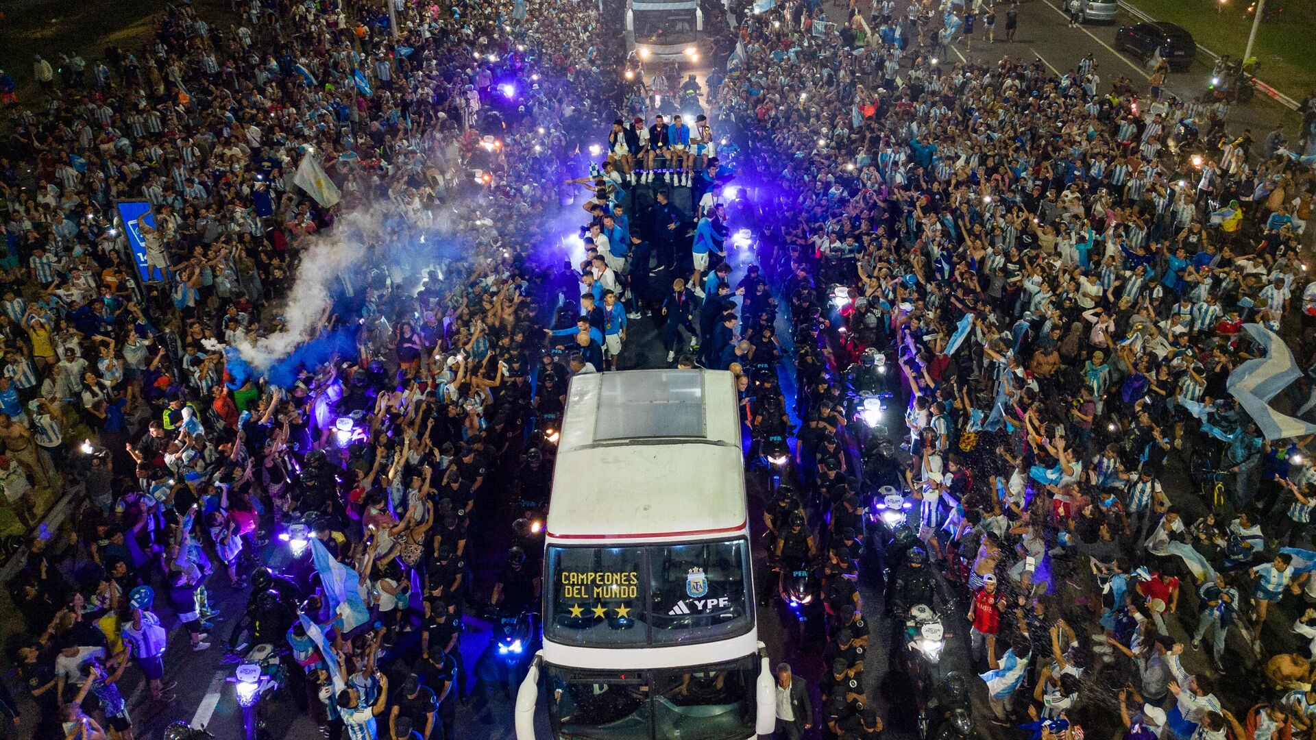 Argentina's players celebrate on board a bus with supporters after winning the Qatar 2022 World Cup tournament as they leave Ezeiza International Airport en route to the Argentine Football Association (AFA) training centre in Ezeiza, Buenos Aires province, Argentina on December 20, 2022. - Sputnik भारत, 1920, 31.12.2022