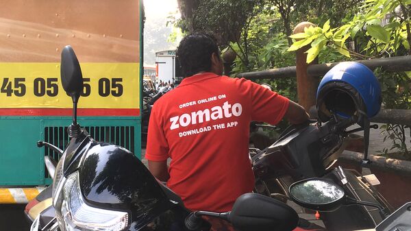 In this photo taken on December 24, 2018, an Indian delivery man working with the food delivery app Zomato sits on his bike in a business district in Mumbai.  - Sputnik भारत