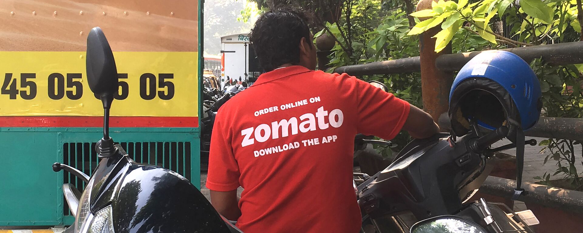 In this photo taken on December 24, 2018, an Indian delivery man working with the food delivery app Zomato sits on his bike in a business district in Mumbai.  - Sputnik भारत, 1920, 02.01.2023