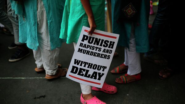 In this April 15, 2018 file photo, an Indian protestor stands with a placard during a protest against two recently reported rape cases as they gather near the Indian parliament in New Delhi, India. - Sputnik India