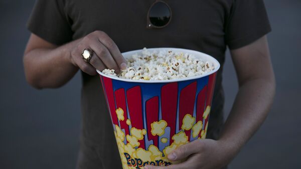 A moviegoer eats popcorn at Mission Tiki drive-in theater in Montclair, Calif., Thursday, May 28, 2020. - Sputnik भारत