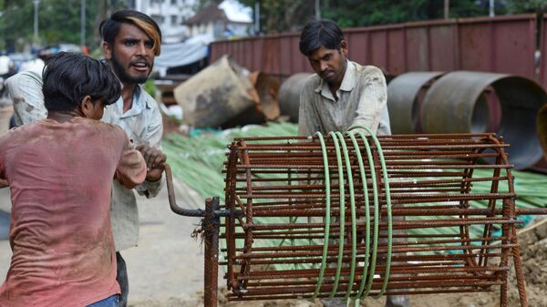 In this picture taken on July 22, 2020, migrant workers roll iron rods at a construction site in Mumbai - Sputnik India