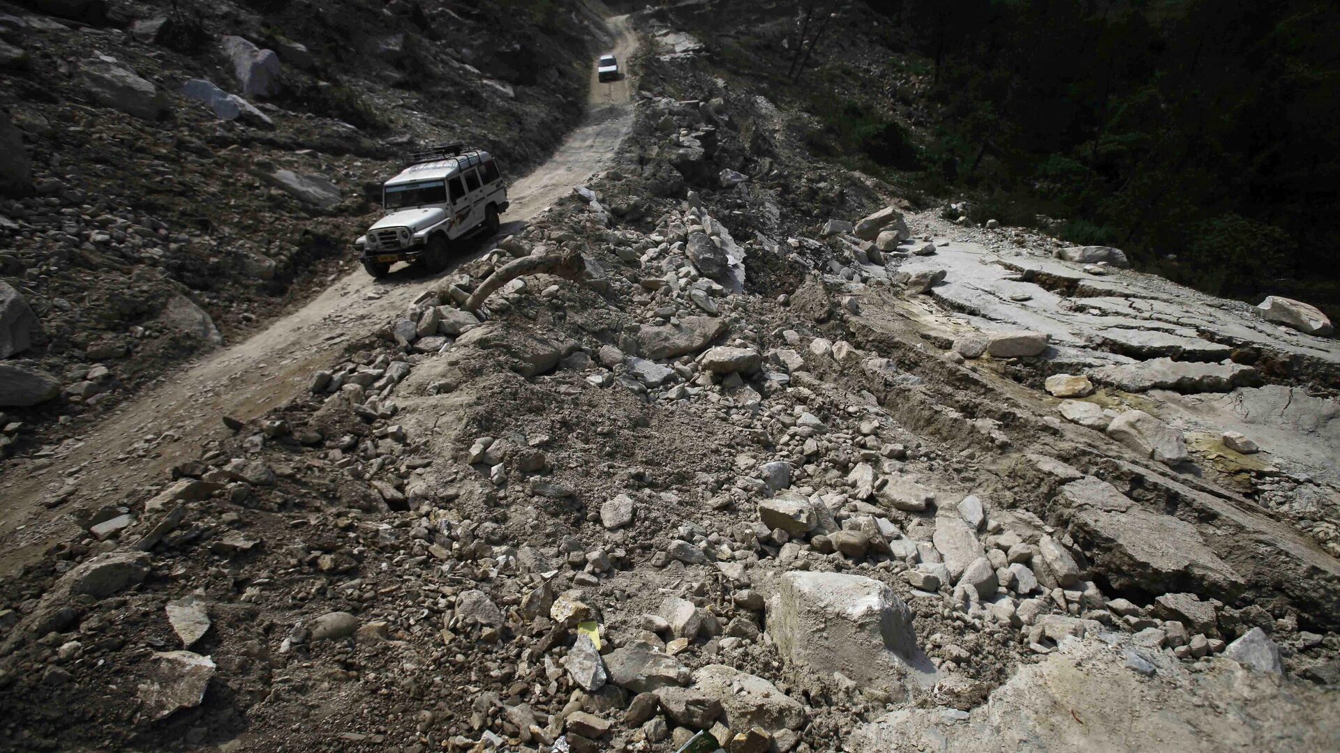  Cars are seen on a road destroyed by landslides and floods,  in Joshimath, India, Friday, June 21, 2013. The heavy rains caused by the annual monsoon have left more than 500 people dead and stranded tens of thousands, mostly pilgrims, in India’s northern mountainous region, officials said Friday.  - Sputnik India, 1920, 05.01.2023