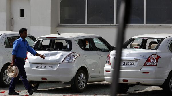 A man walks past cars damaged by workers who rioted at the Maruti Suzuki factory in Manesar, near New Delhi, India, Thursday, July 19, 2012. - Sputnik India