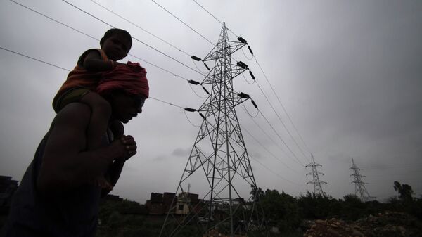 A man carries his son on his shoulders as he walks by electric towers in Jammu, India (File) - Sputnik India