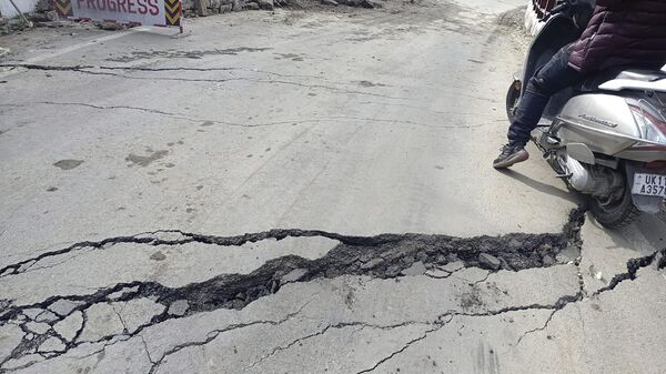 A motorist navigates his way through a crack on a road in Joshimath, India, Tuesday, Jan. 3, 2023. - Sputnik India
