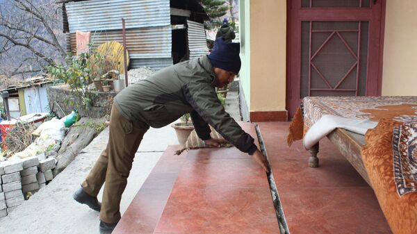A policeman checks a crack in a house in Joshimath, in Chamoli district of Uttarakhand on January 11, 2023, after authorities in one of the holiest towns in the Indian Himalayas were evacuating panicked residents on January 8 after hundreds of houses began developing yawning cracks and sinking, officials said. - Sputnik India
