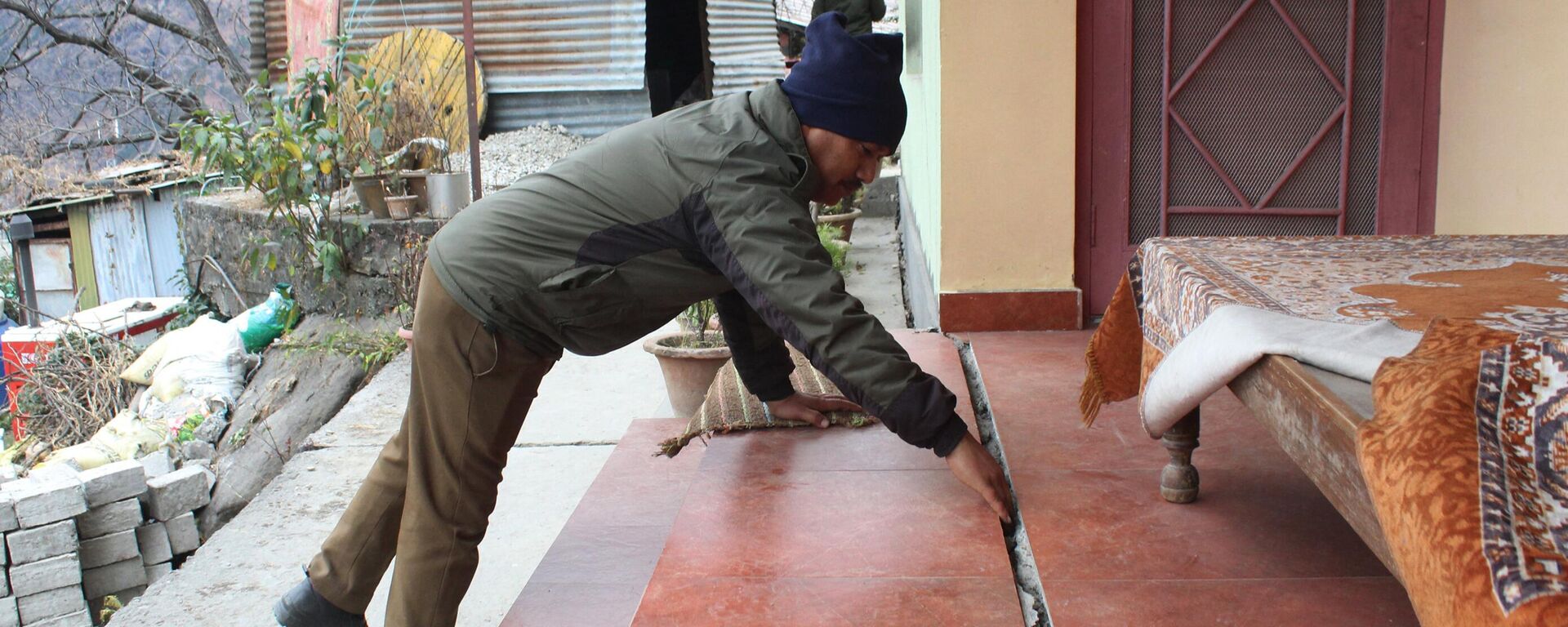 A policeman checks a crack in a house in Joshimath, in Chamoli district of Uttarakhand on January 11, 2023, after authorities in one of the holiest towns in the Indian Himalayas were evacuating panicked residents on January 8 after hundreds of houses began developing yawning cracks and sinking, officials said. - Sputnik भारत, 1920, 12.01.2023