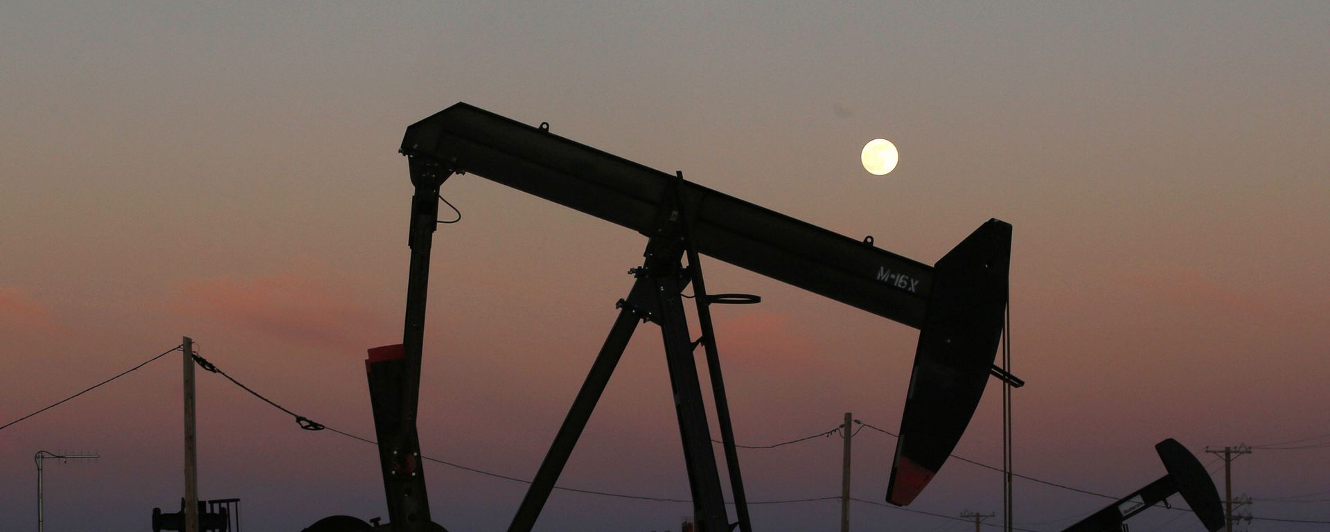 FILE - In this June 8, 2017, file photo, oil derricks are busy pumping as the moon rises near the La Paloma Generating Station in McKittrick, Calif. The U.S. is on pace to leapfrog both Saudi Arabia and Russia as the world’s biggest oil producer - Sputnik India, 1920, 04.04.2024
