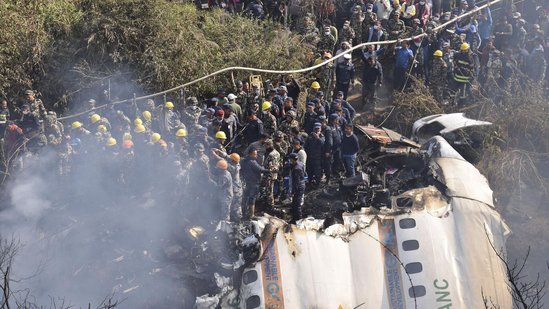 Nepalese rescue workers and civilians gather around the wreckage of a passenger plane that crashed in Pokhara, Nepal, Sunday, Jan. 15, 2023.  - Sputnik India, 1920, 15.01.2023