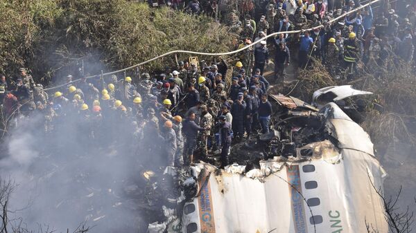 Nepalese rescue workers and civilians gather around the wreckage of a passenger plane that crashed in Pokhara, Nepal, Sunday, Jan. 15, 2023.  - Sputnik India