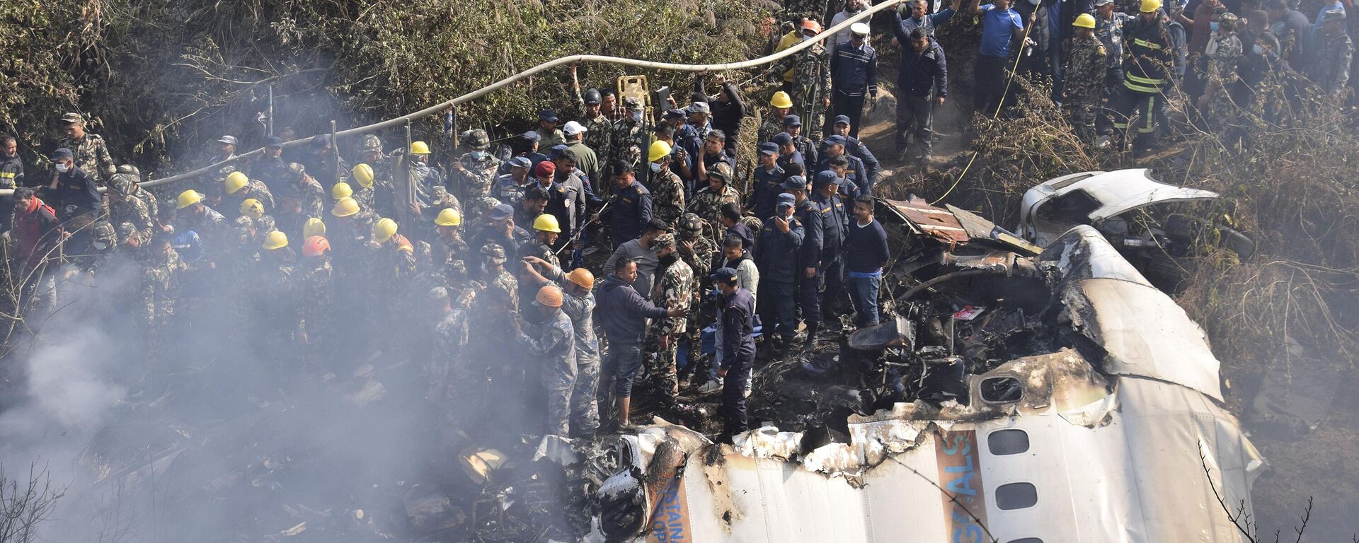 Nepalese rescue workers and civilians gather around the wreckage of a passenger plane that crashed in Pokhara, Nepal, Sunday, Jan. 15, 2023.  - Sputnik भारत, 1920, 15.01.2023